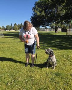 Trainer teaching a dog to sit instead of jumping